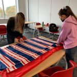 Students cutting cloth for a no sew blanket